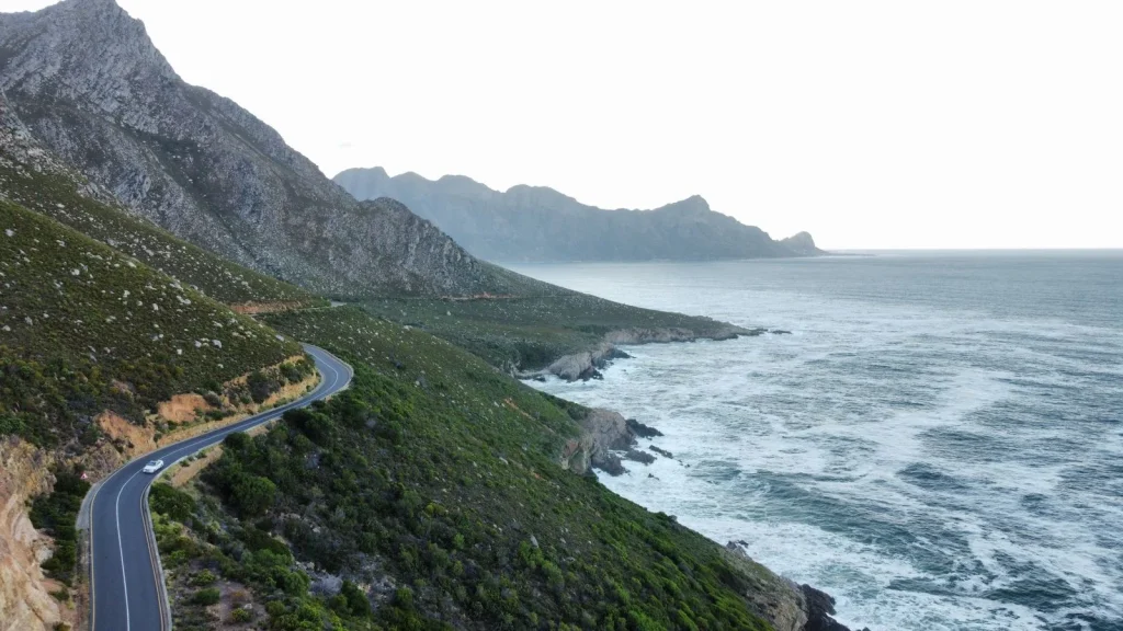 Coastal road curving between rugged mountains and the ocean